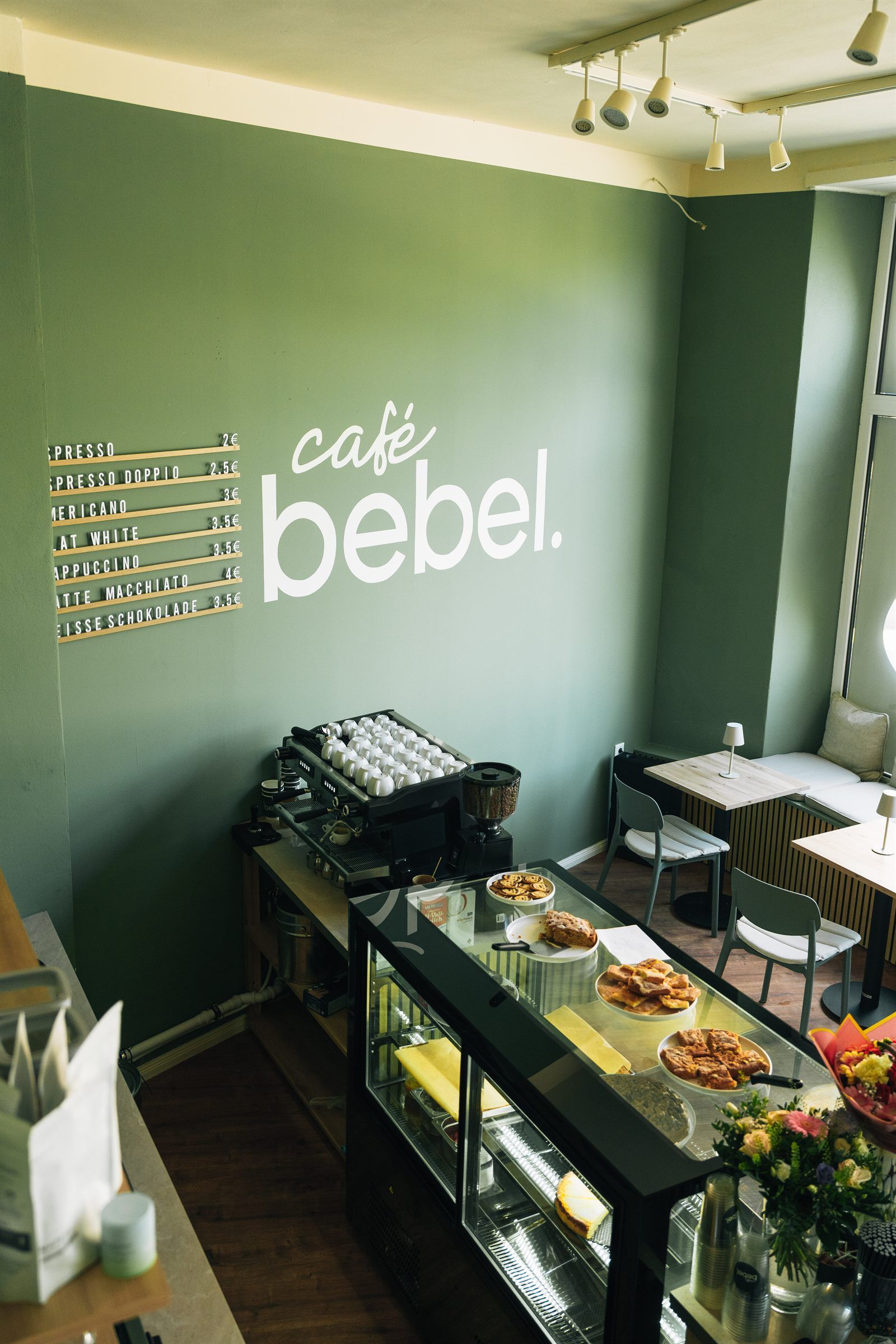 Theke des Café Bebel mit Espressomaschine, Tafel-Karte und Kuchenvitrine