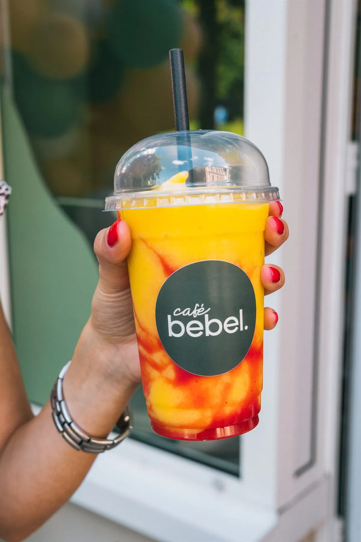 Hand hält einen Café-Bebel-Becher