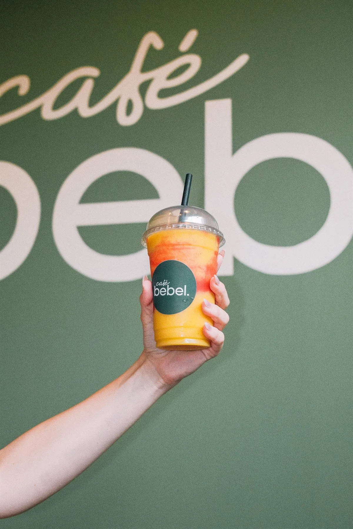 Hand hält einen Café-Bebel-Becher mit Matcha